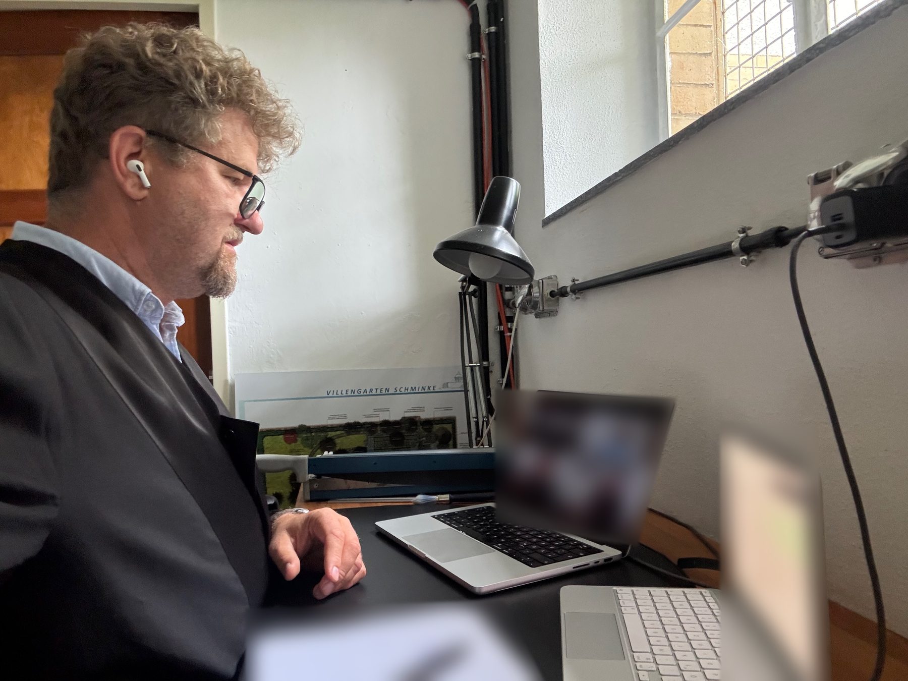 Rechtsanwalt Rainer Huke in Robe bei einer Gerichtsverhandlung per Video